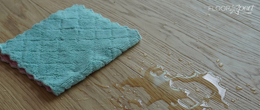 cleaning up a pool of water on engineered wood flooring
