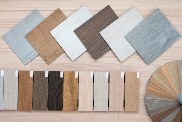 A flat lay of outdoor flooring samples in square tile and plank formats, featuring grey, brown, white, and natural wood-tone finishes - FloorXpert
